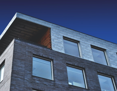 A large brick building with lots of windows against a blue sky
