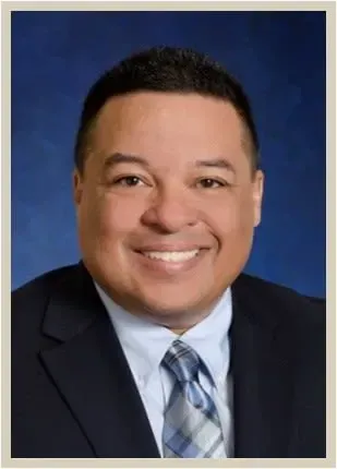 A man in a suit and tie is smiling for the camera.
