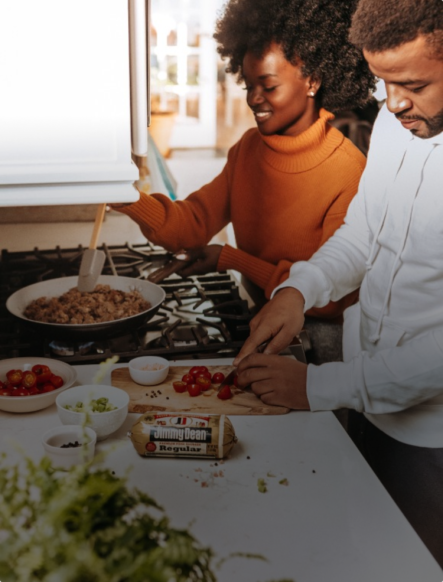 A man and a woman are preparing food in a kitchen.