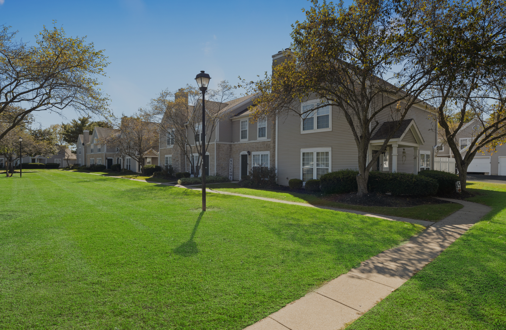 A row of houses sitting next to each other on a lush green lawn.