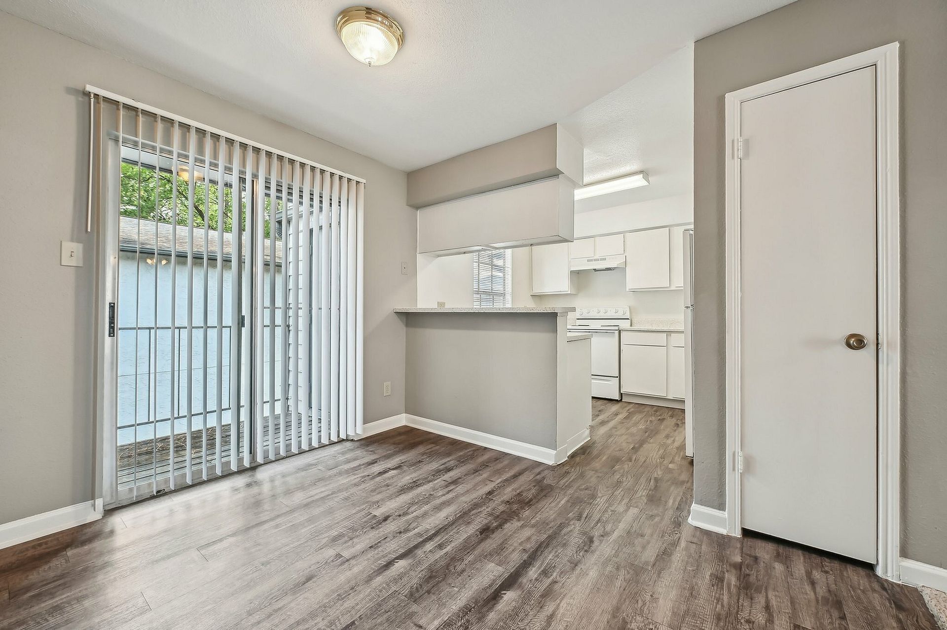 Living area with a sliding glass patio door and open kitchen.