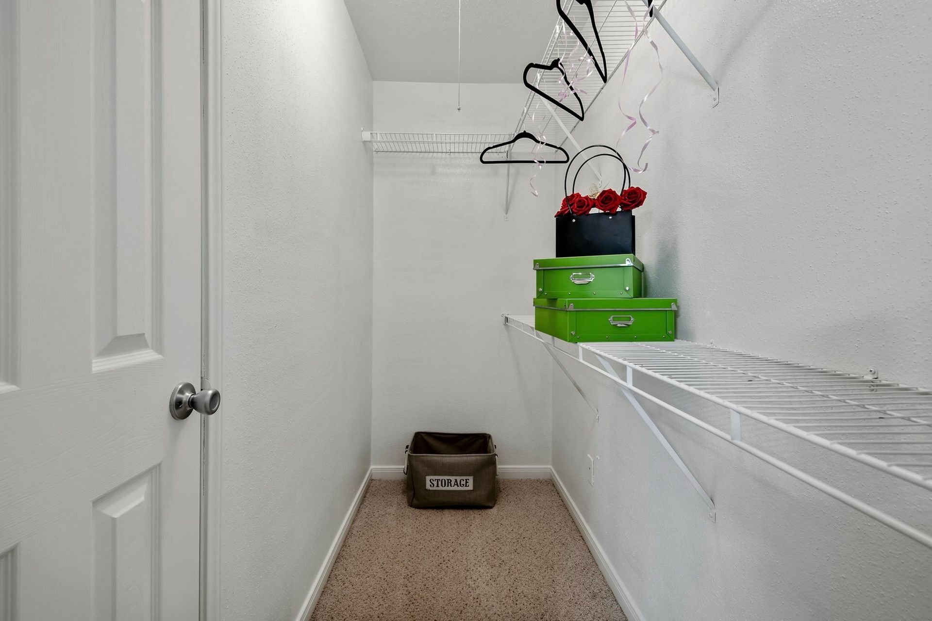 Walk-in closet with wire shelving, hanging rods, and storage boxes.