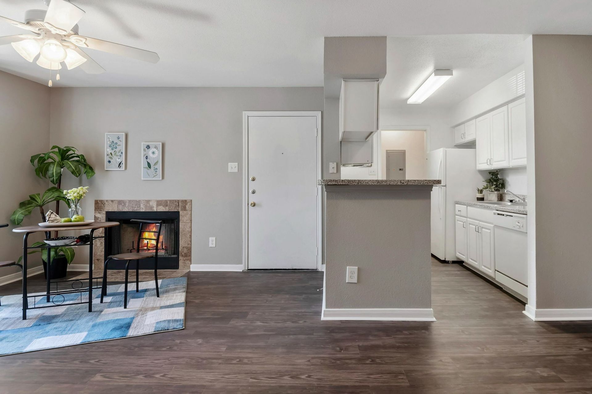 Open living area with a fireplace, small dining table, and an open kitchen.