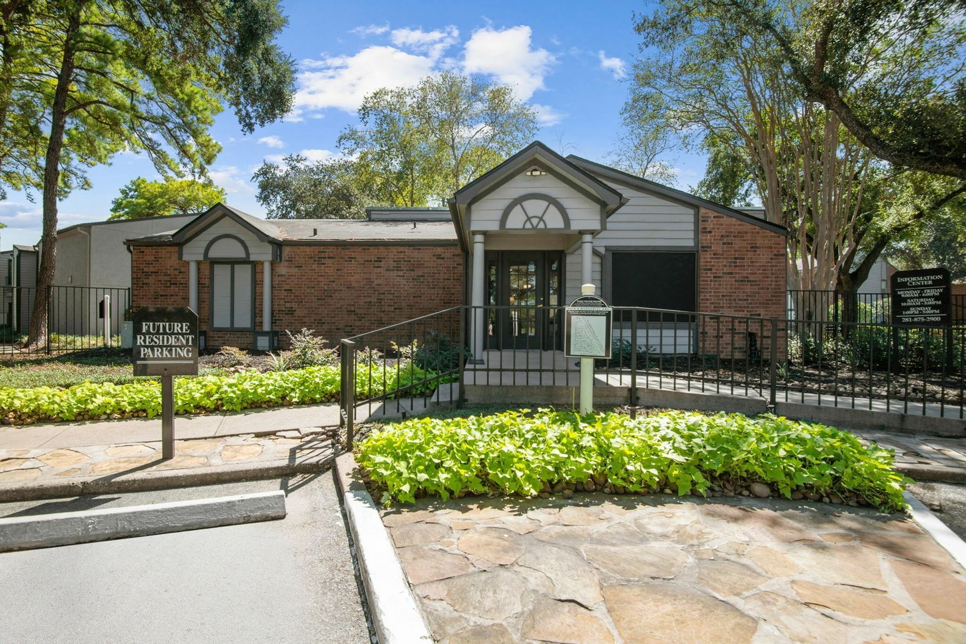 Leasing office building with brick exterior, gated path, and landscaped entrance.