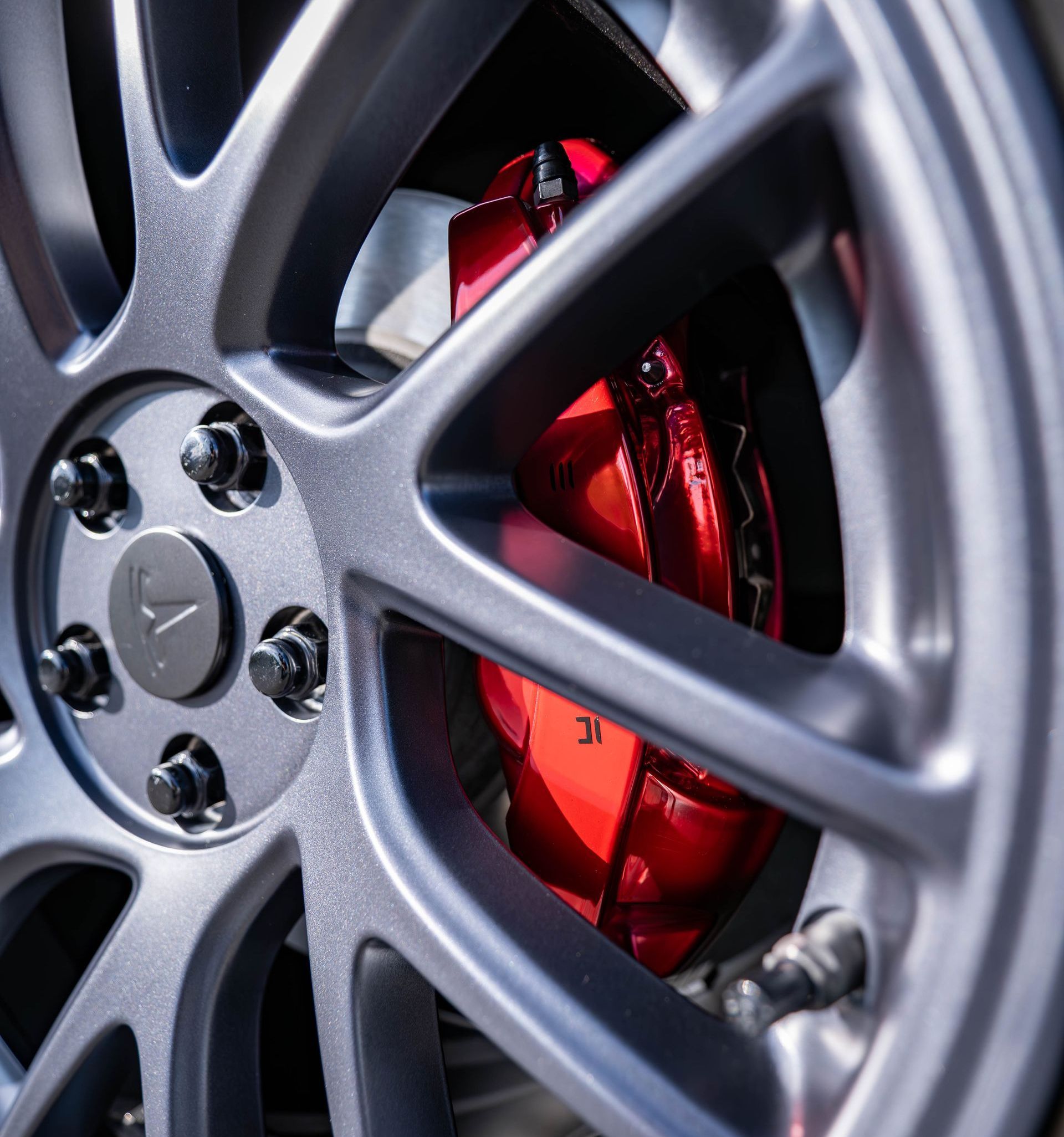 A close up of a car wheel with red brake calipers.
