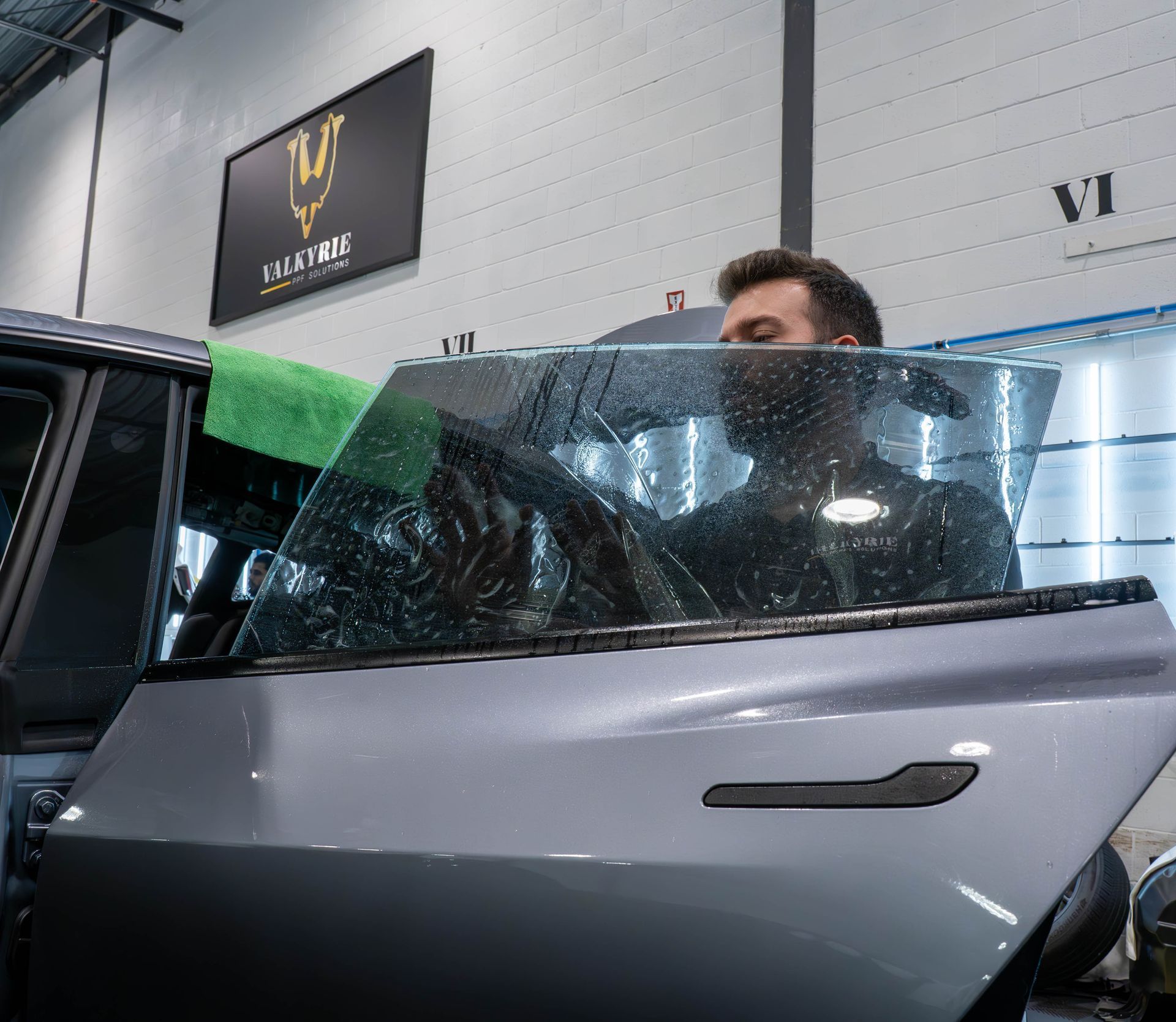 A man is sitting in a chair in front of a car.