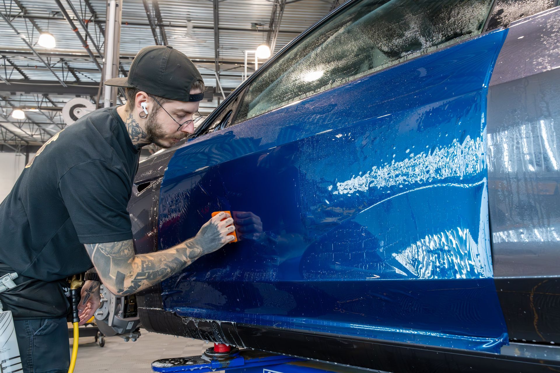 Two men are working on a car in a garage.