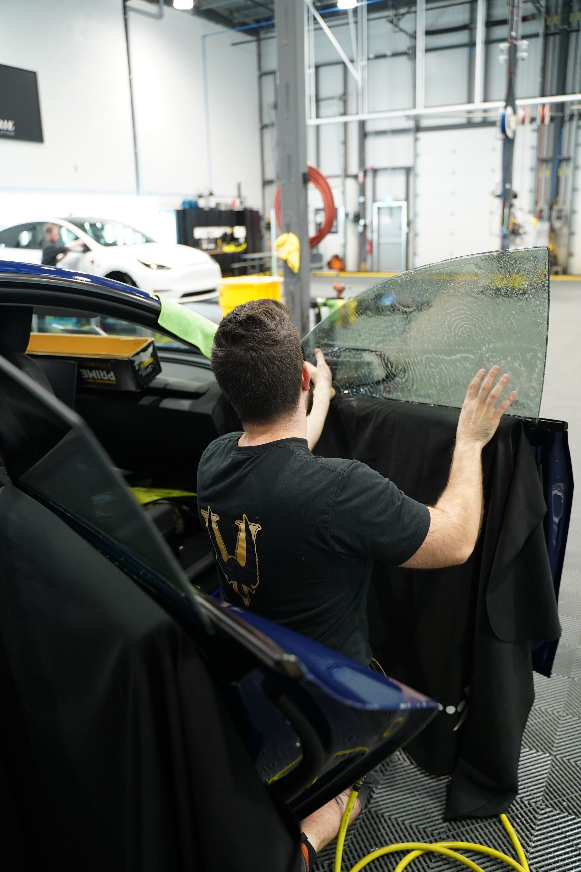 A man is sitting in a chair in front of a car.