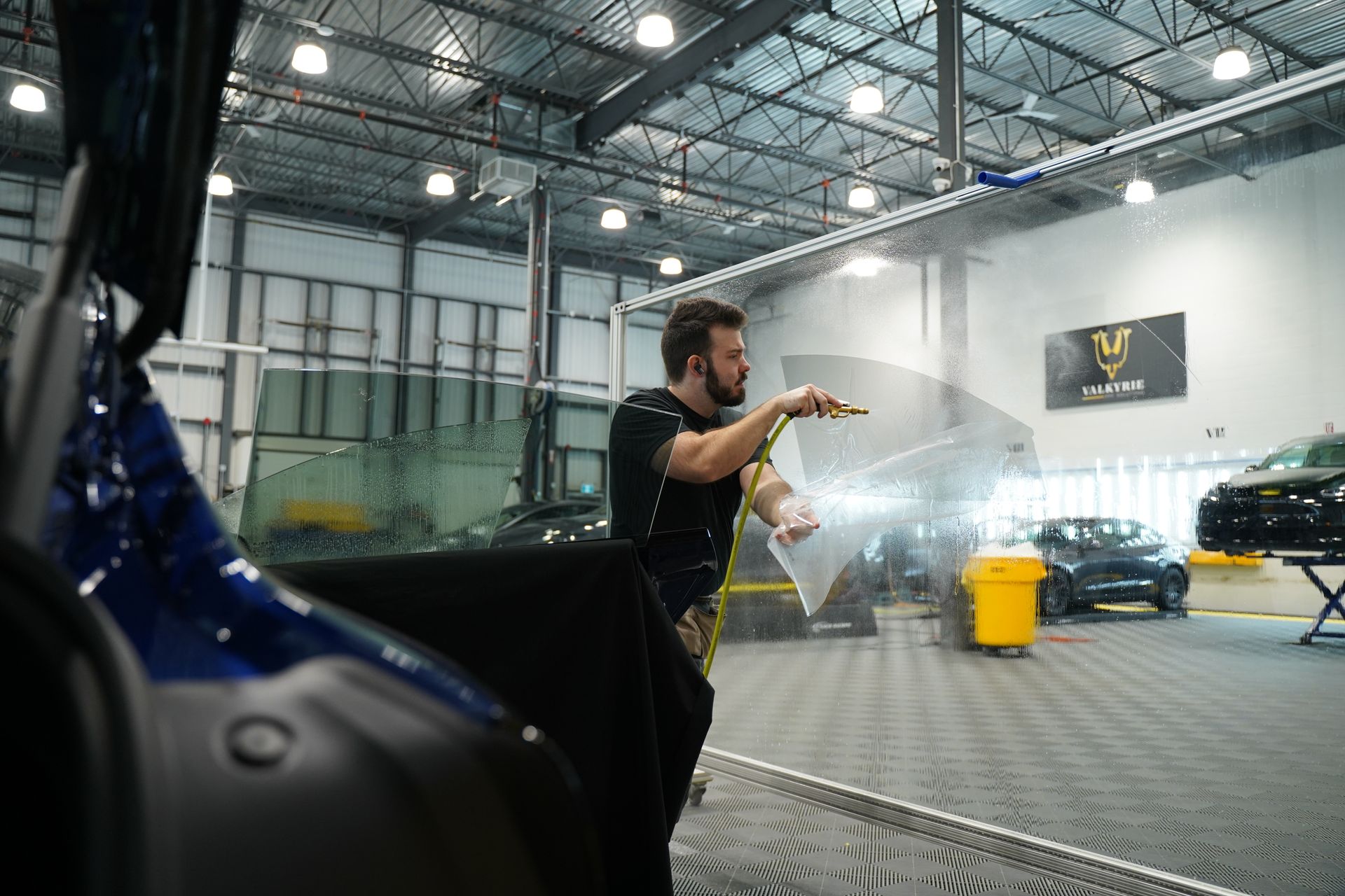 A man is cleaning a car in a garage.