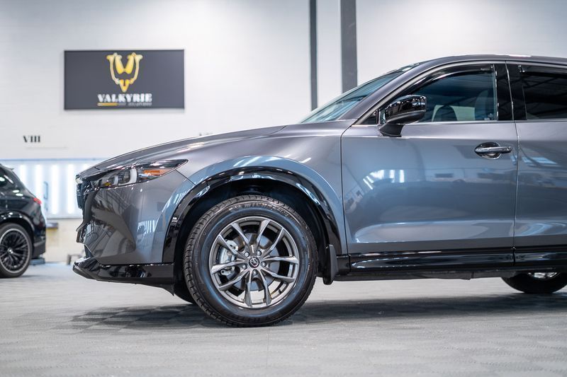Gray SUV in a showroom, side view with front wheel visible