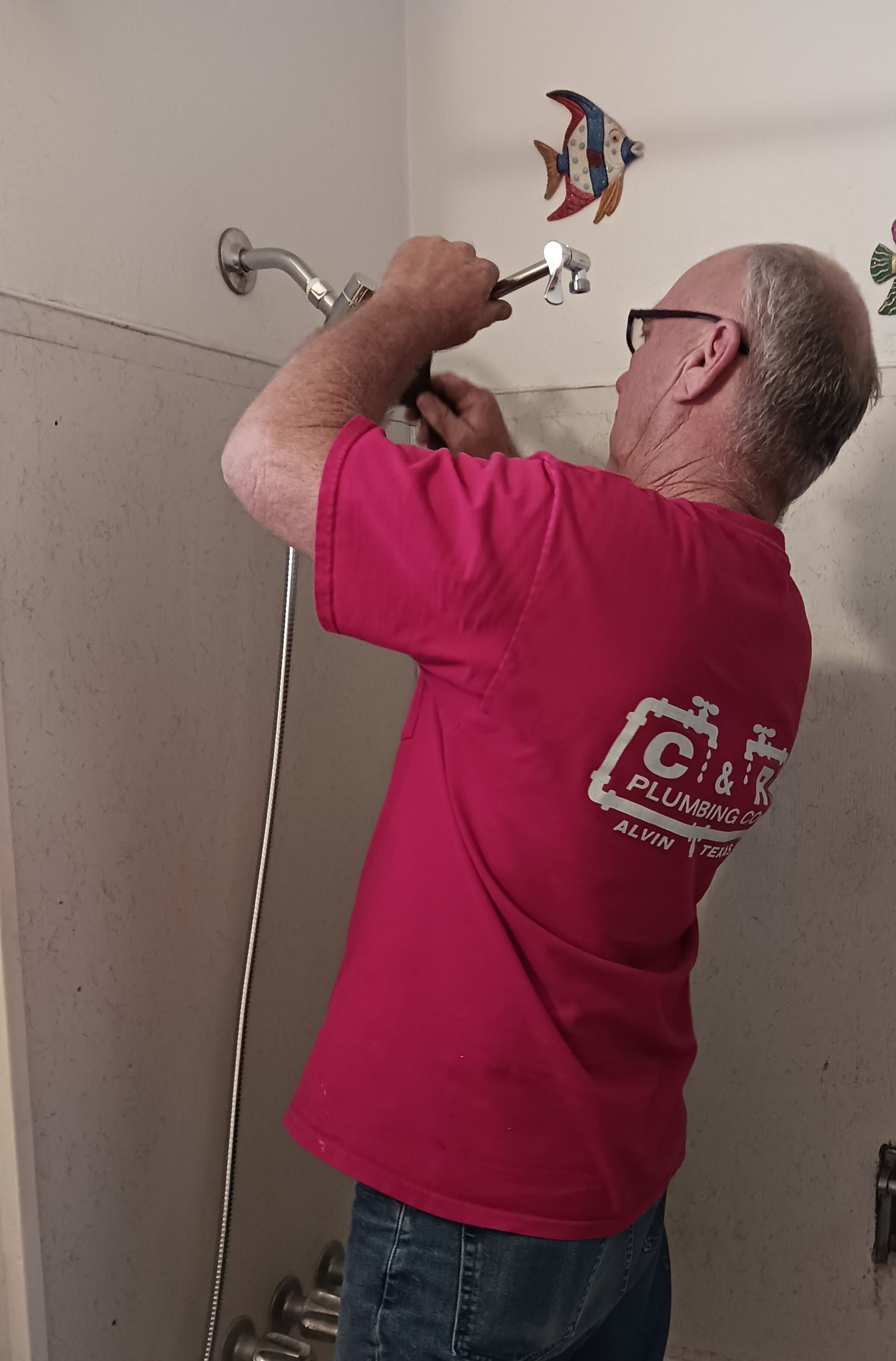 A Plumber Working On A Shower Fixture
