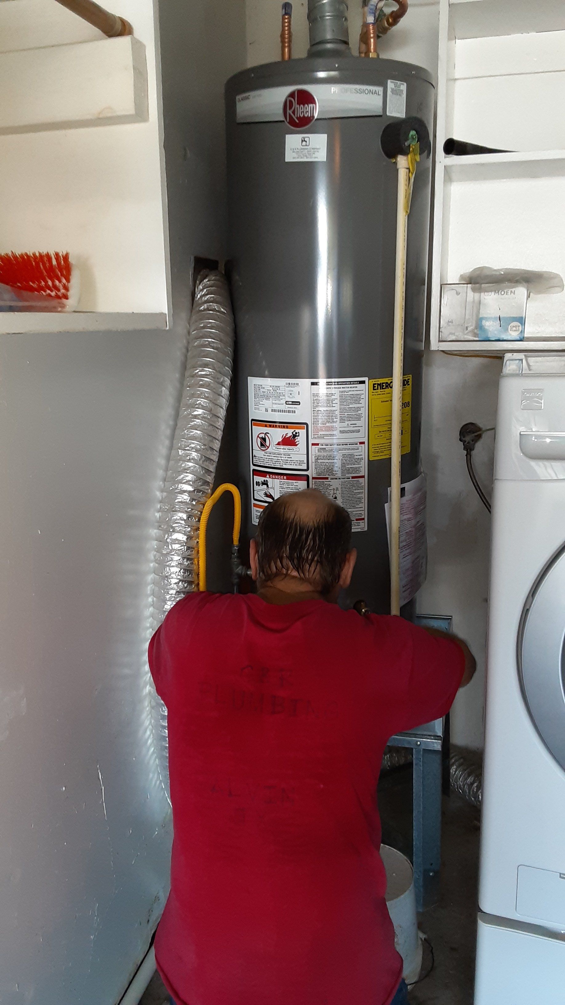 Man Working On A Rheem Water Heater
