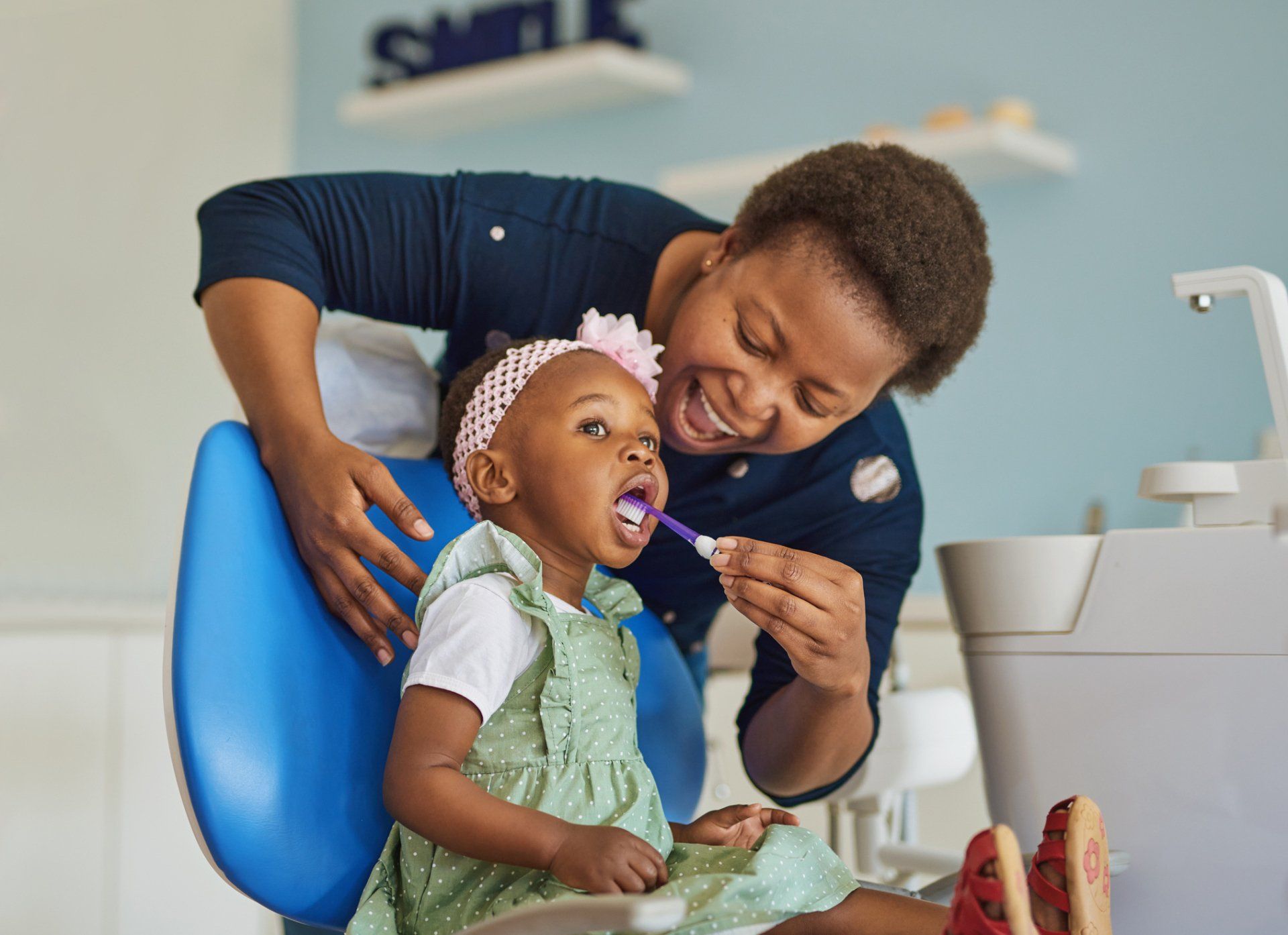 Young woman brushing her adorable daughter’s teeth — Madison, WI — East Grove Dental Young woman brushing her adorable daughter’s teeth — Madison, WI — East Grove Dental