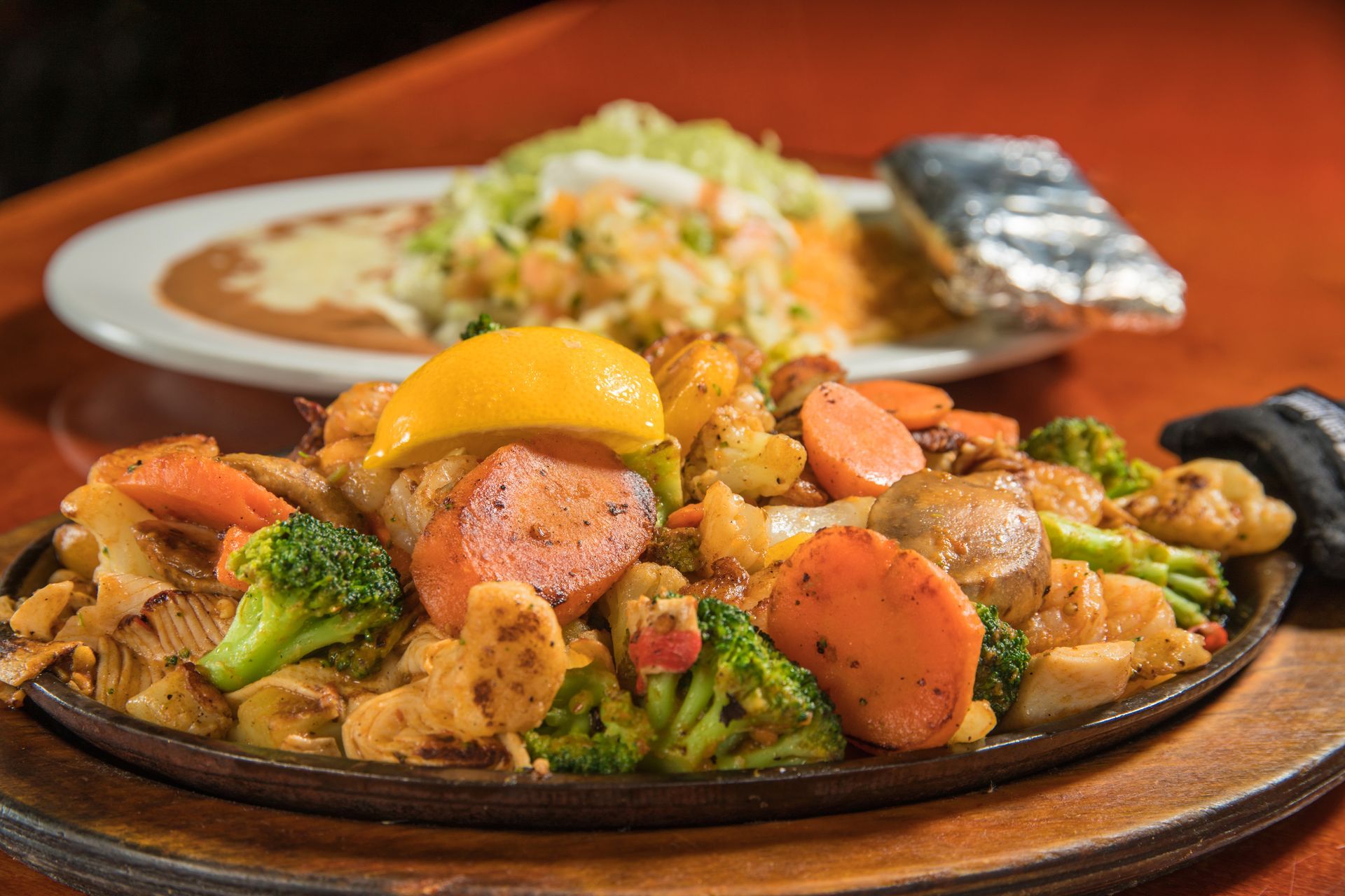 A close up of a plate of food on a table with a plate of food in the background.