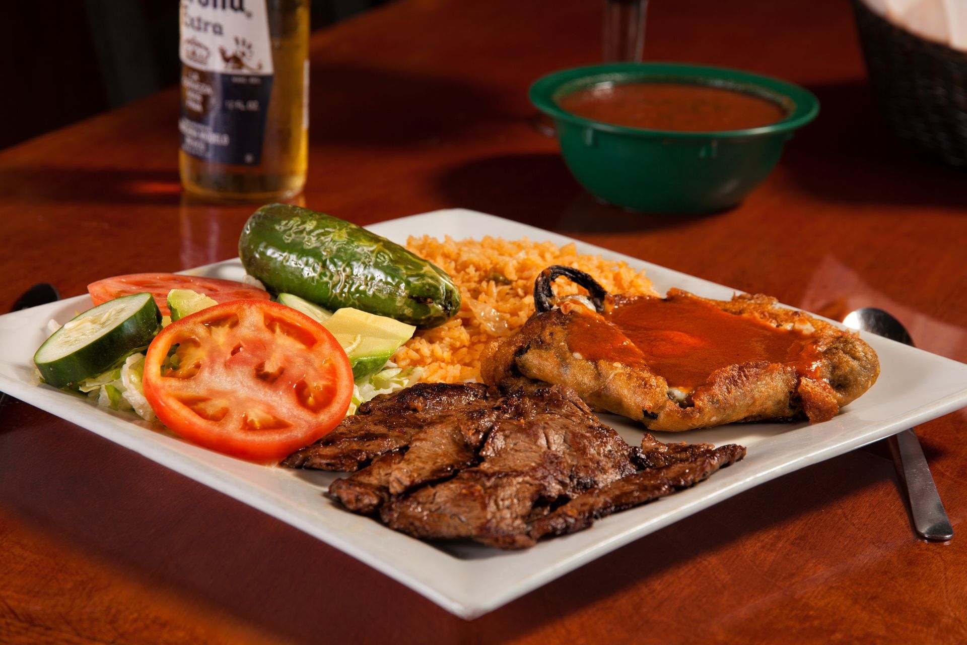 A white plate topped with meat and vegetables on a table.