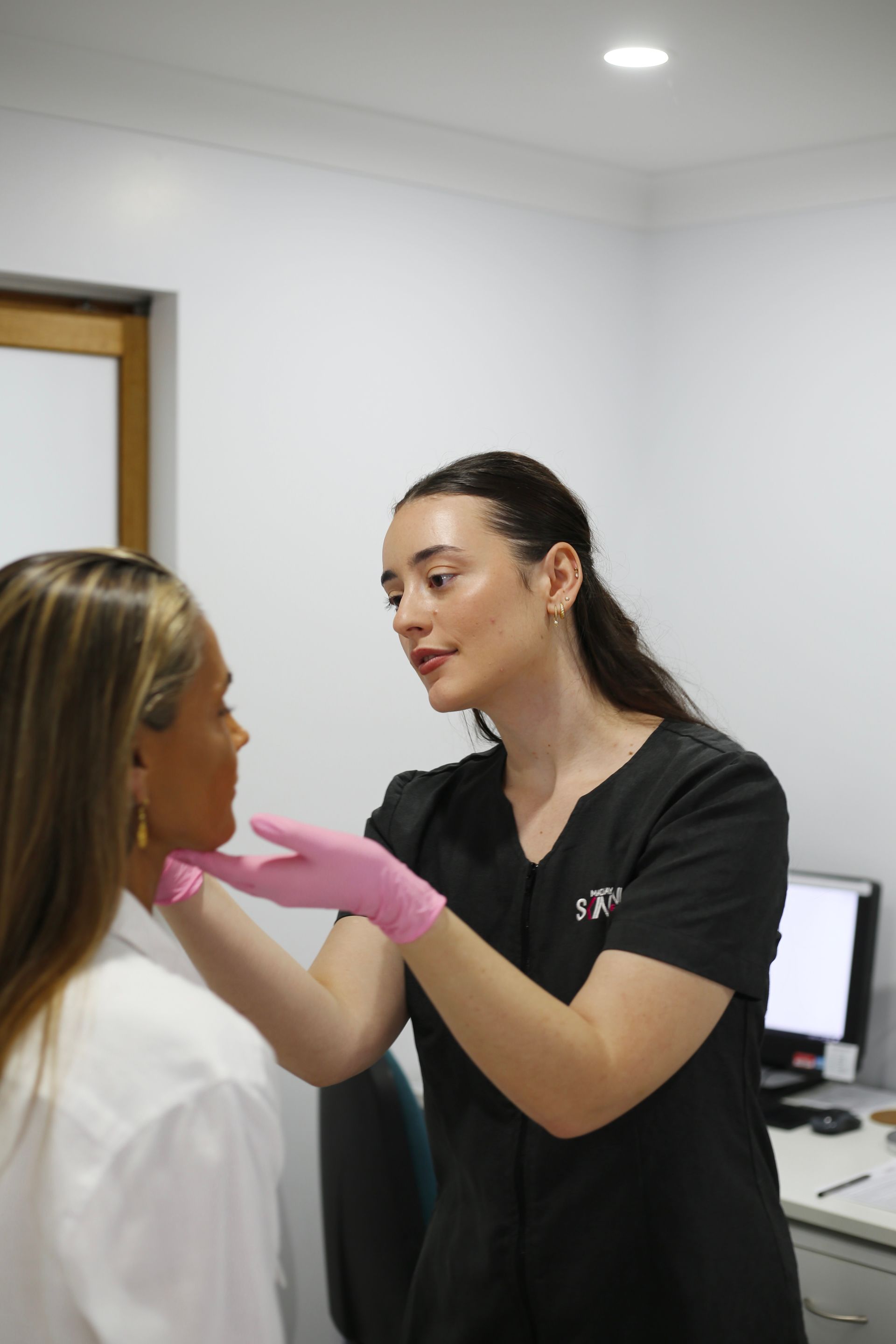 A Woman Is Getting An Airbrush Treatment On Her Face — Mackay Skin Clinic In North Mackay, QLD