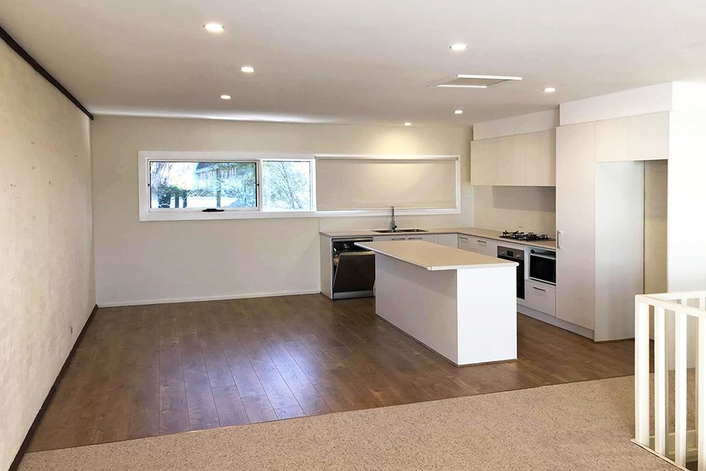 An Empty Kitchen With a Large Island in the Middle of the Room — Imperial Build Co. in Coombs, ACT