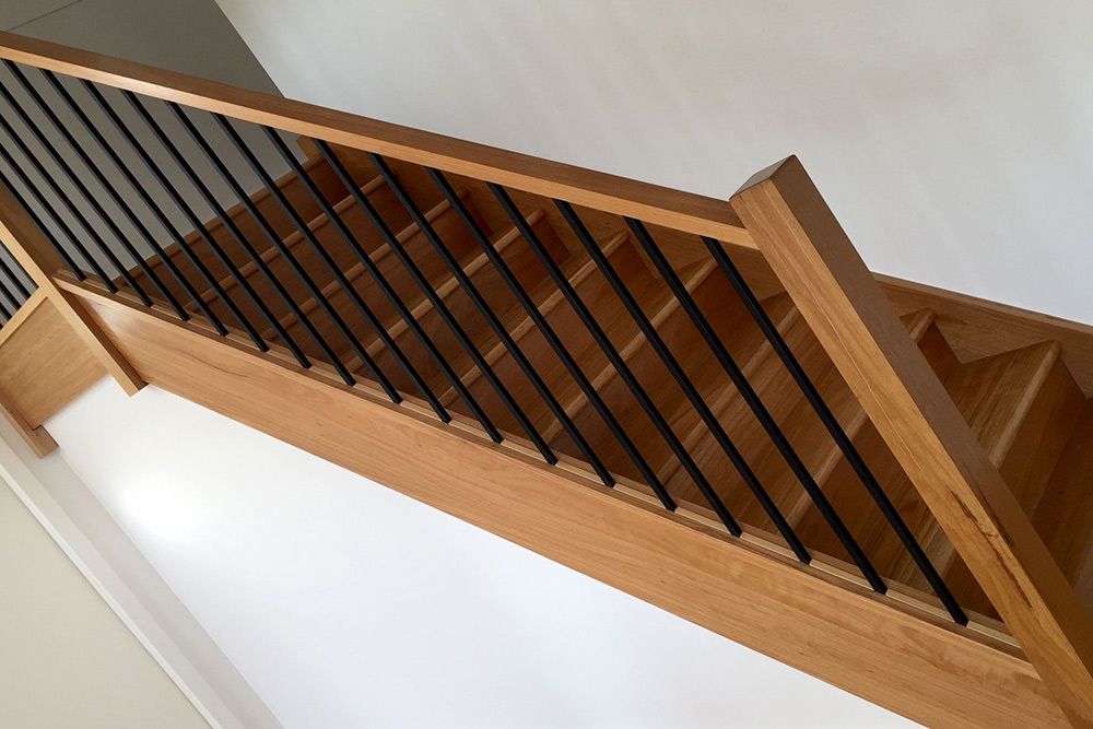 A Wooden Staircase With a Black Railing in a House — Imperial Build Co. in Coombs, ACT