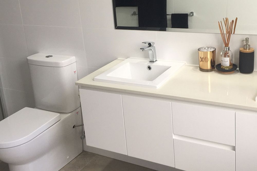 A Bathroom With a Toilet, Sink and Mirror — Imperial Build Co. in Coombs, ACT