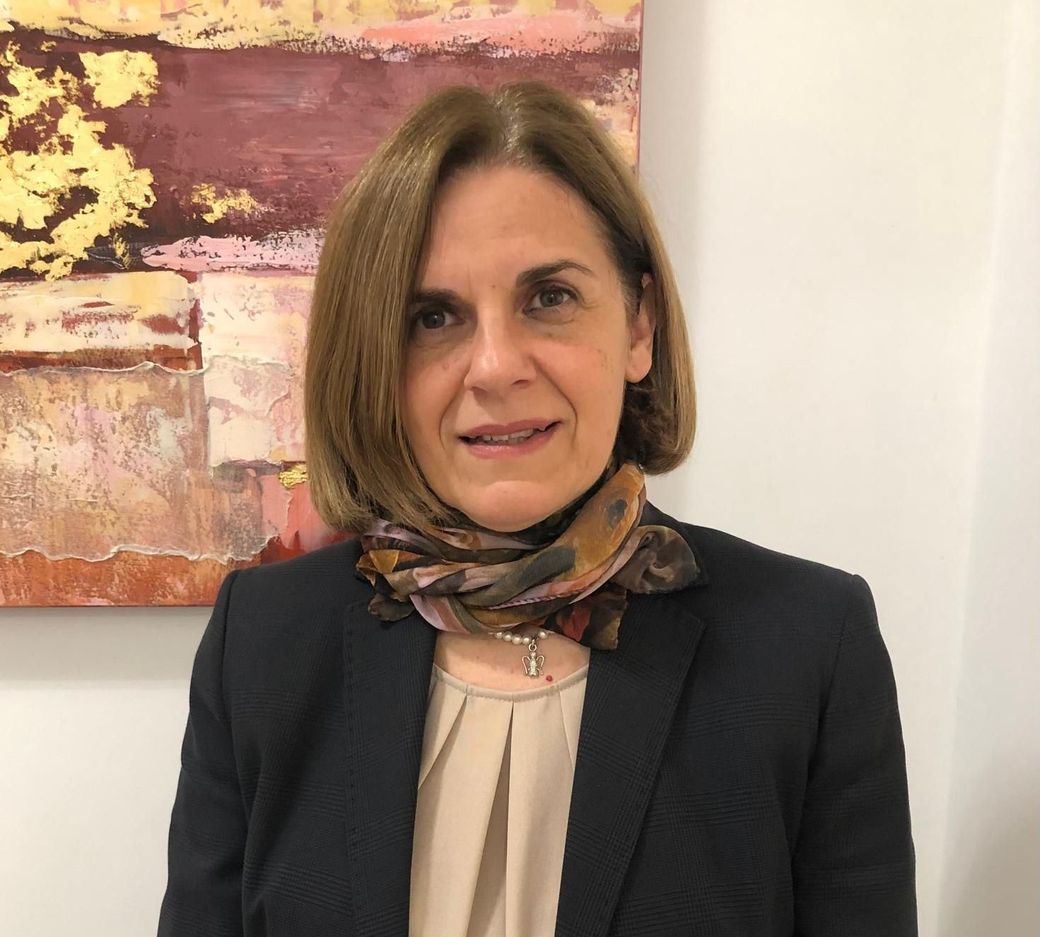 Una donna sta scrivendo su un pezzo di carta con una penna.