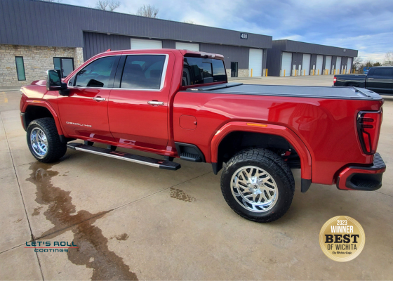 A red truck is parked in front of a building.