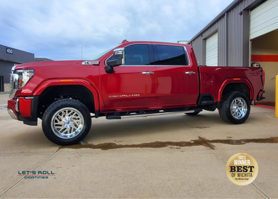 A red pickup truck is parked in front of a garage with a sticker that says ' the best ' on it