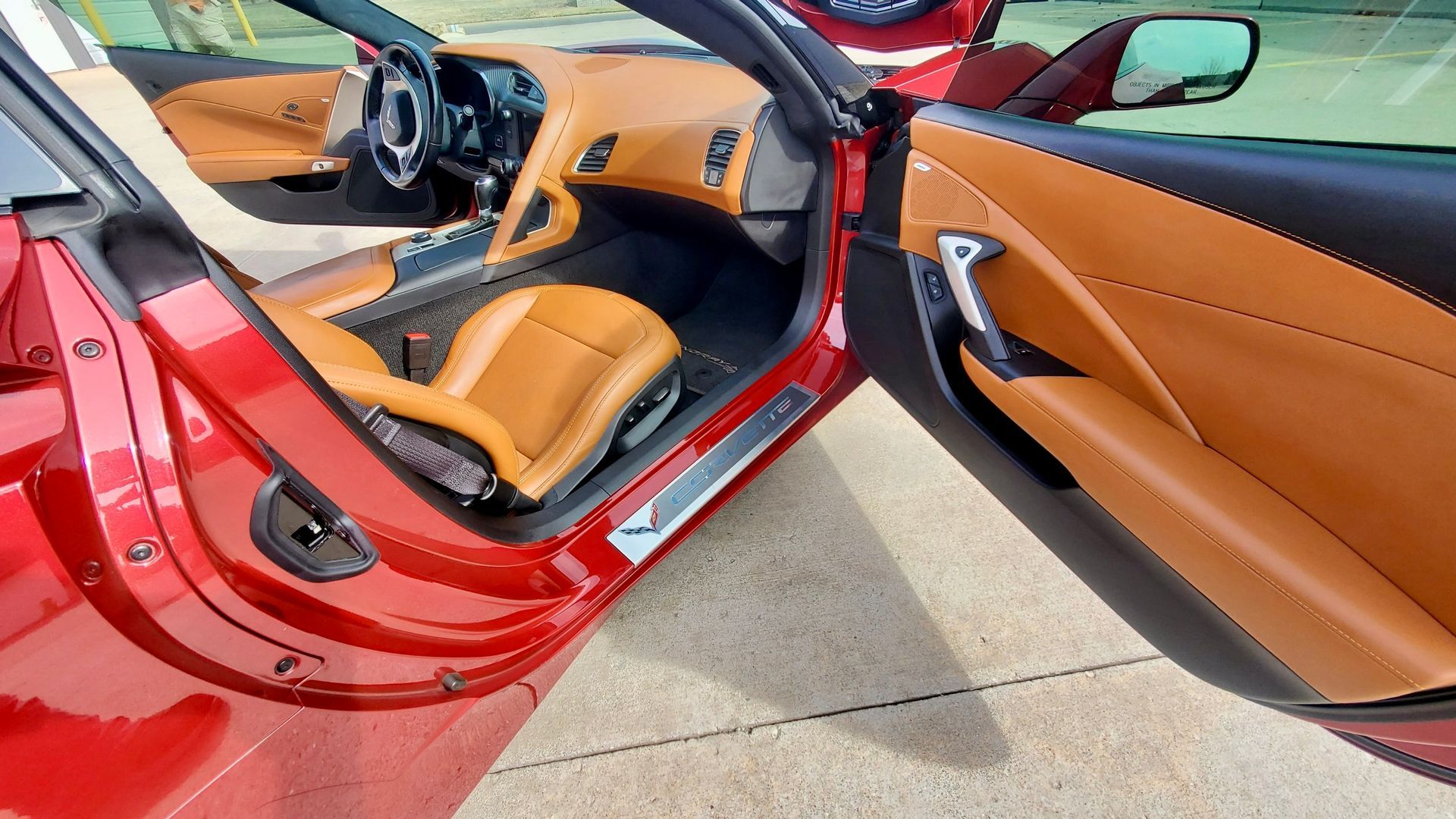 Red car interior with tan leather seats and door panel.