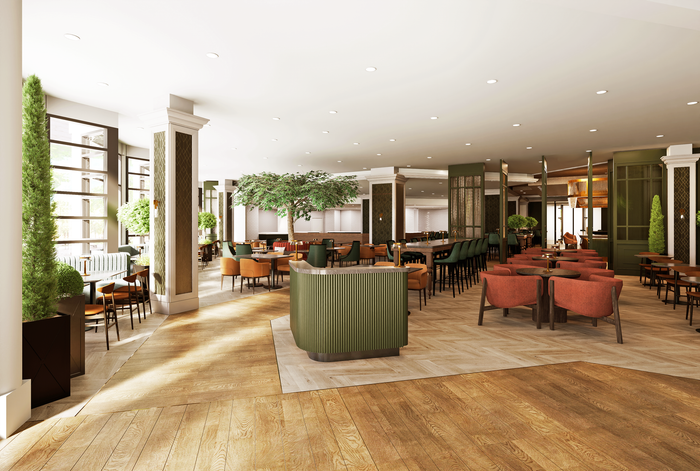 Bright, modern hotel lounge with orange chairs, green planter, and large windows looking onto trees