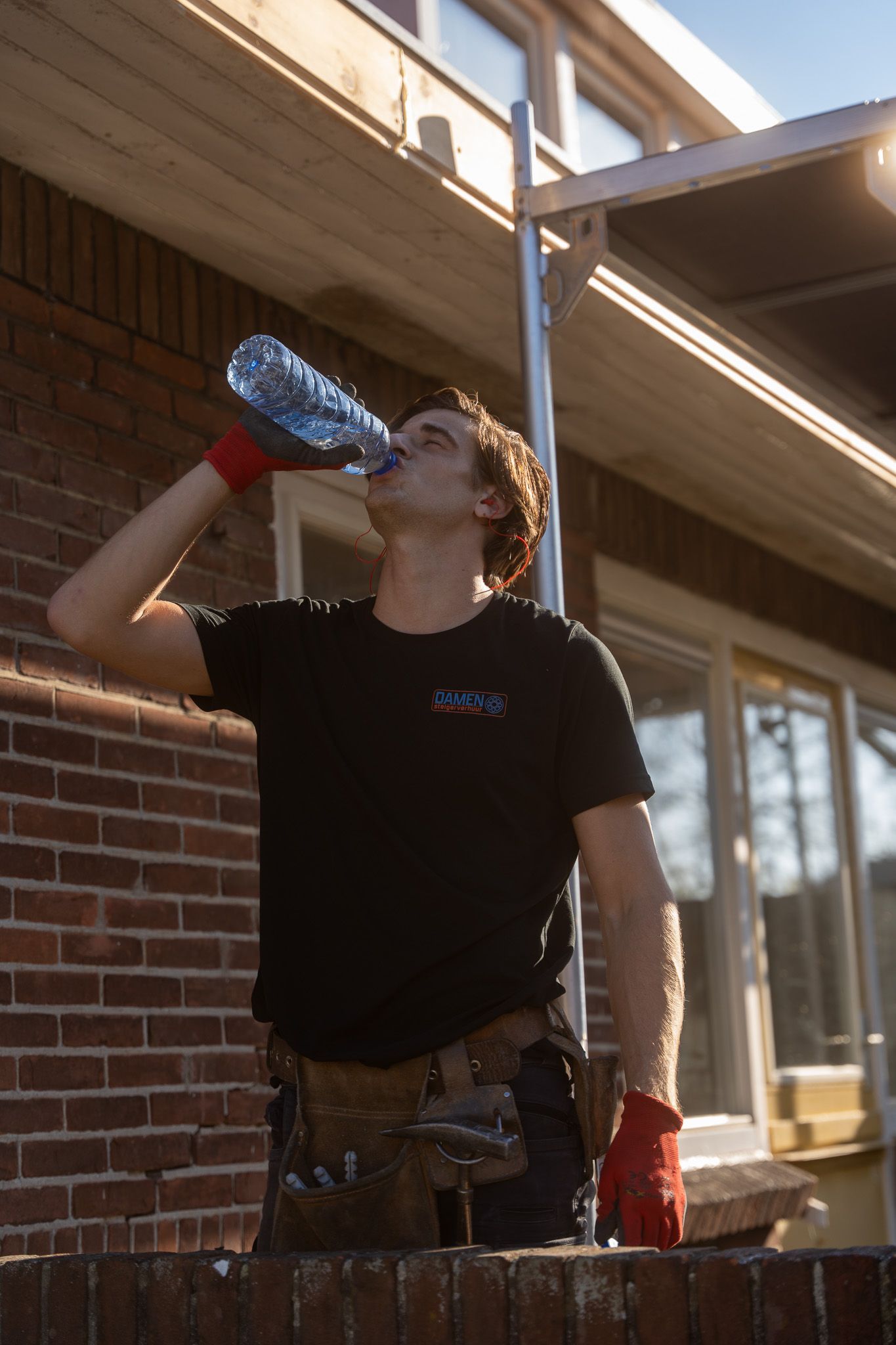 Een man drinkt water uit een plastic fles
