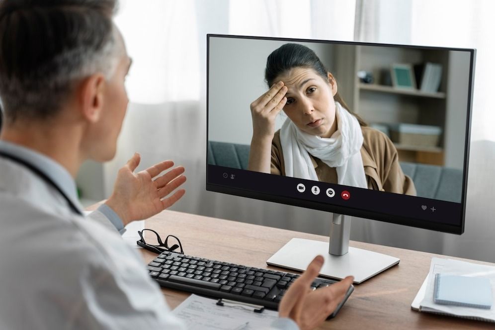 A telepsychiatry is talking to a patient on a video call.