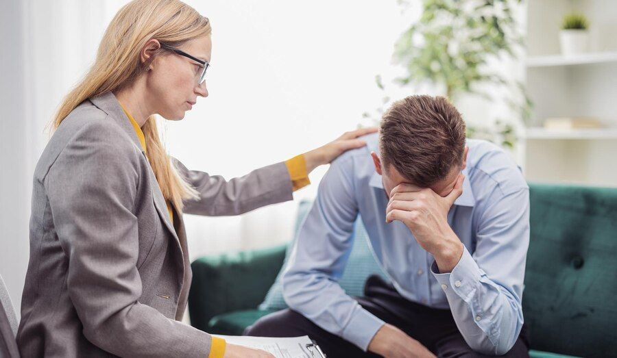 A Woman Engaged In Conversation With A Man On A Couch In A Psychotherapy Session