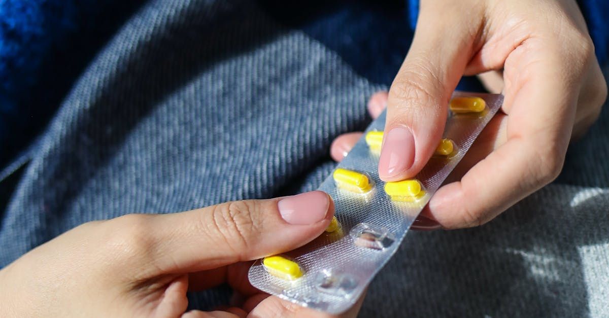 A Person Holding A Pill In Their Hand