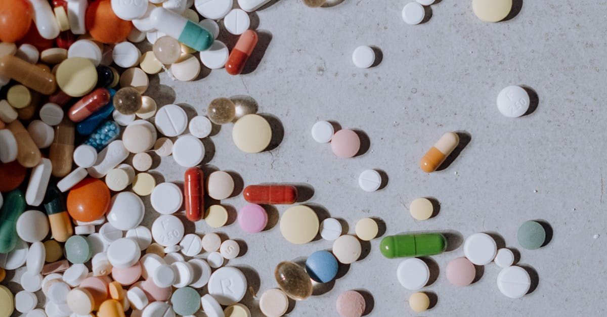 There are many different types of pills and capsules on the table.