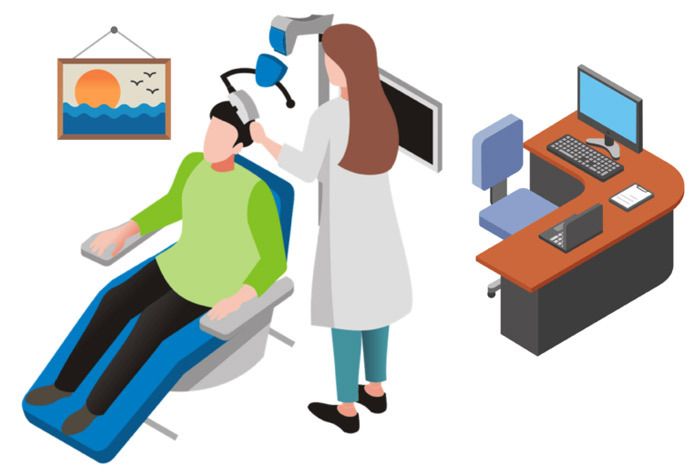 A man is sitting in a TMS chair while a doctor examines his head.
