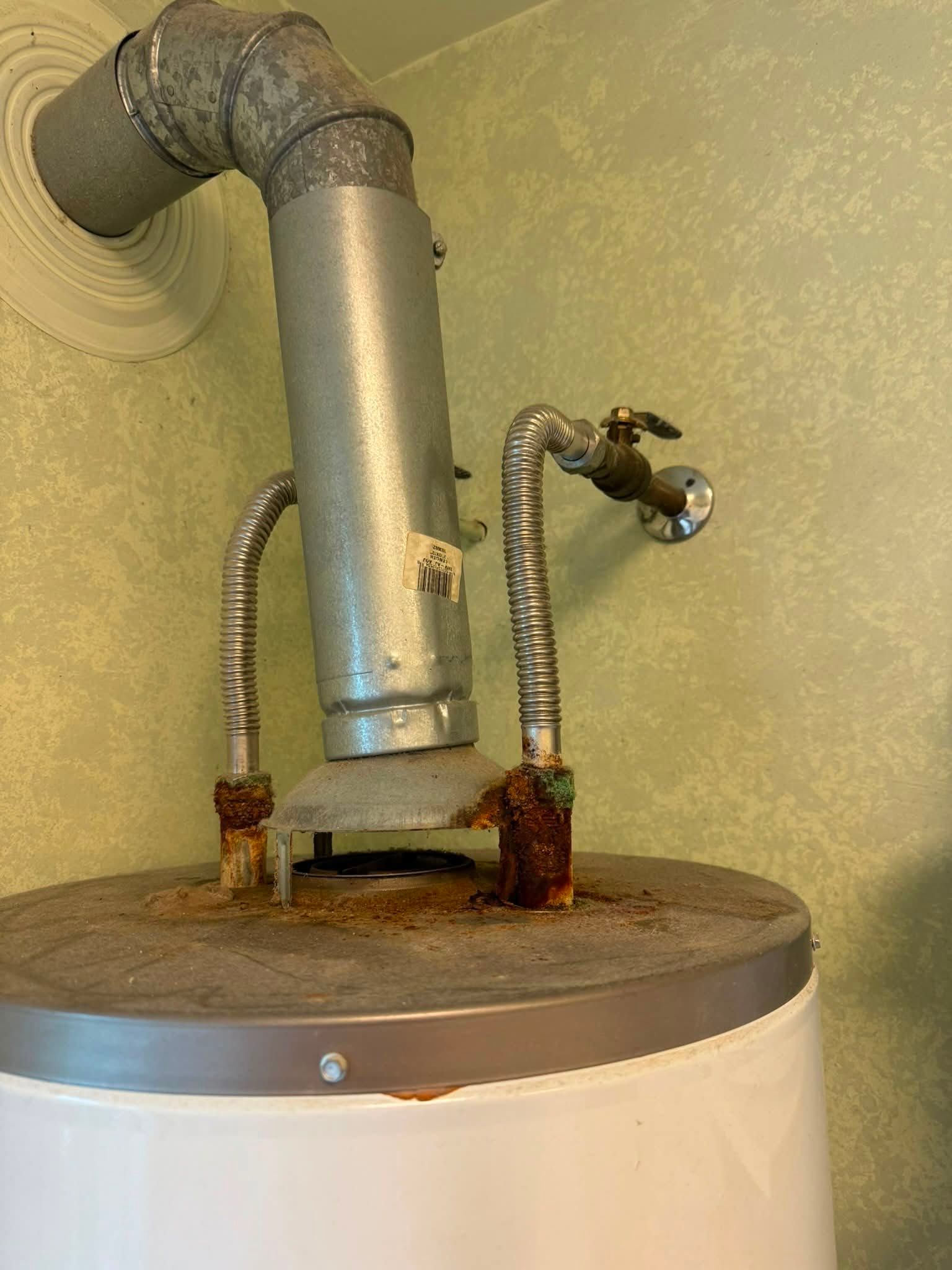 Tank with vent pipe and flexible hoses connected to a wall-mounted plumbing fixture