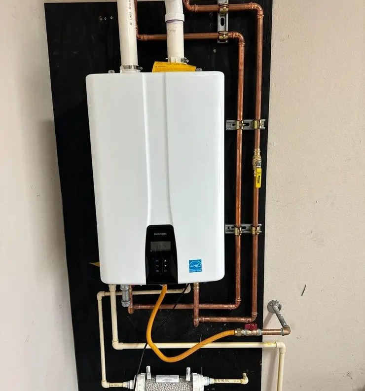 White wall-mounted boiler with exposed copper and white plumbing pipes in a utility room.