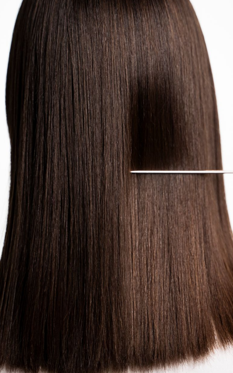 Straight, dark brown hair against a white background.