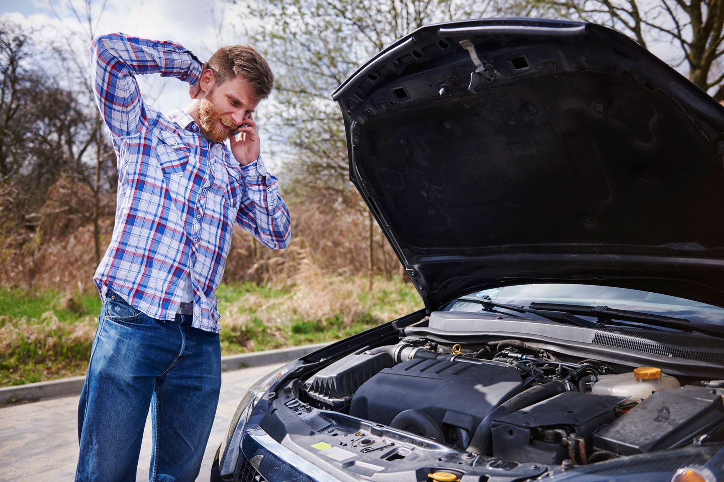 A man with car troubles calling a tow truck company