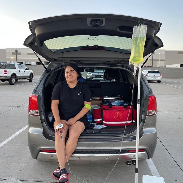 A woman is sitting in the back of a car