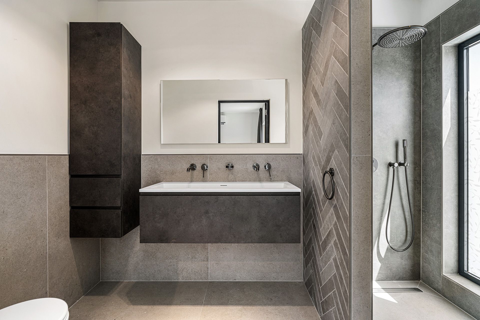 Modern bathroom with gray walls, a floating vanity, and a glass shower.