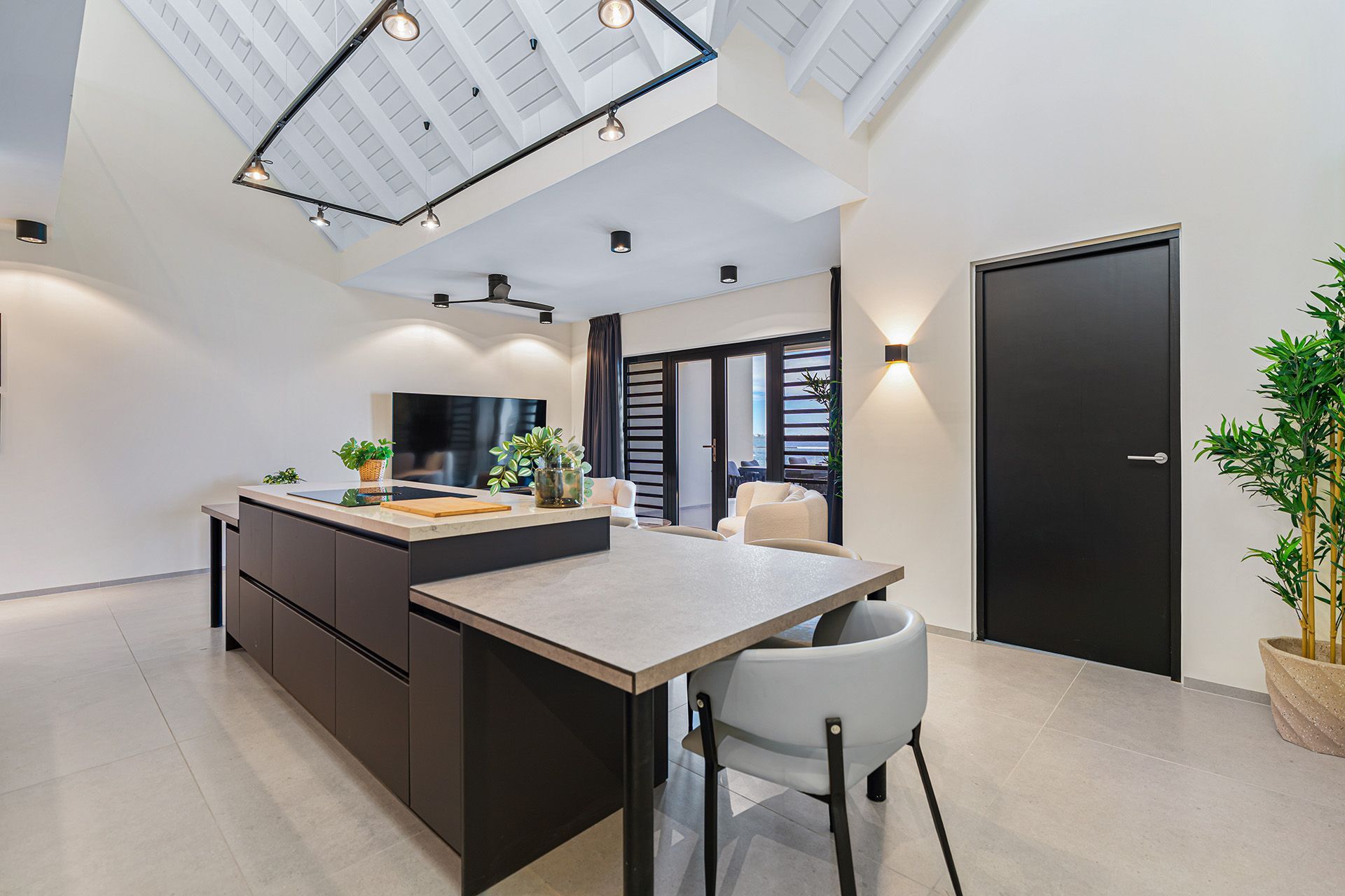Modern kitchen with a dark island and a dining table.