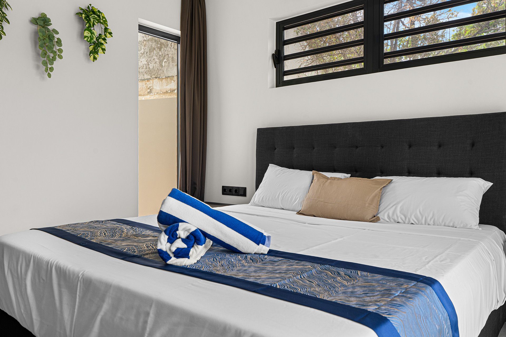 Bedroom with a large bed, a dark headboard, and blue and white linens.