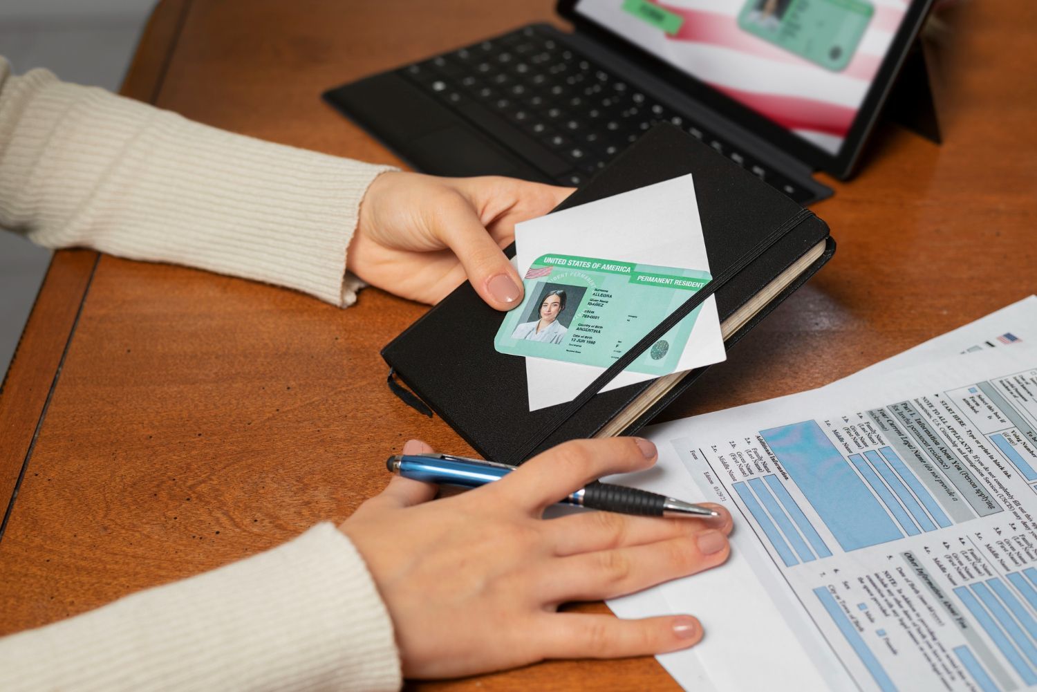 An elderly couple examines paperwork together at a table, one pointing while the other types on a laptop.