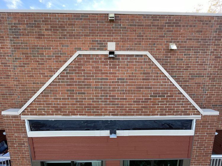 An aerial view of a brick building with a white awning over the entrance.