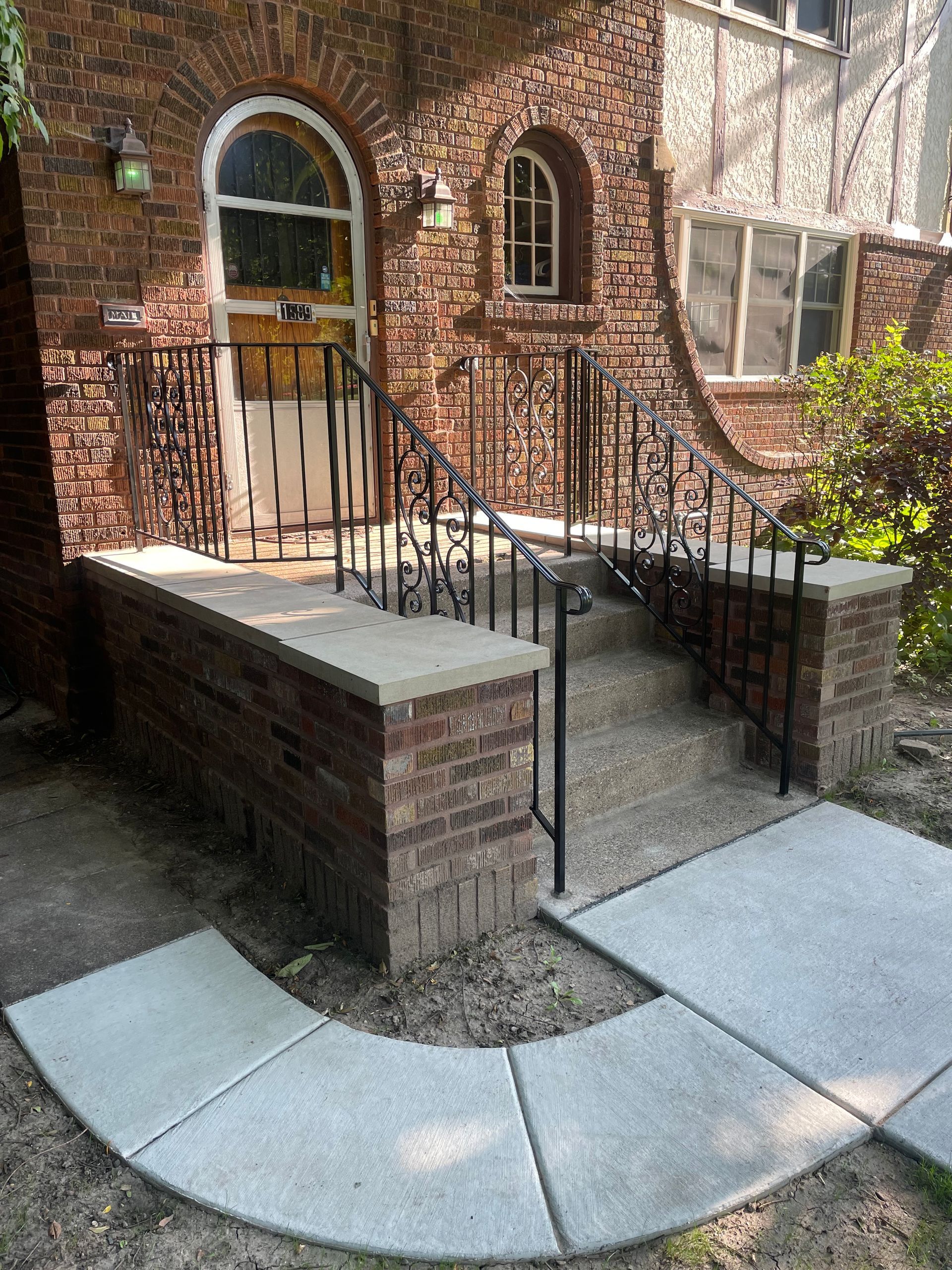 A brick building with a concrete walkway leading to it