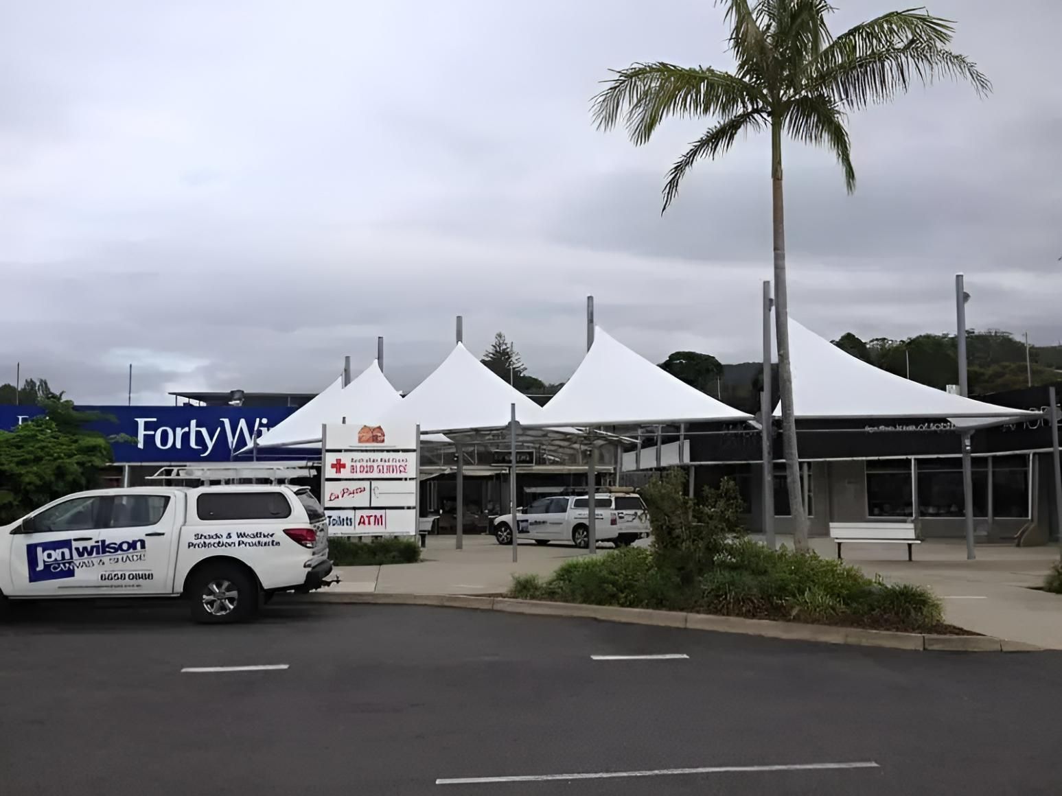 A White Truck Is Parked in Front of A Store Called Forty Winks  — Jon Wilson Canvas & Shade in Coffs Harbour, NSW