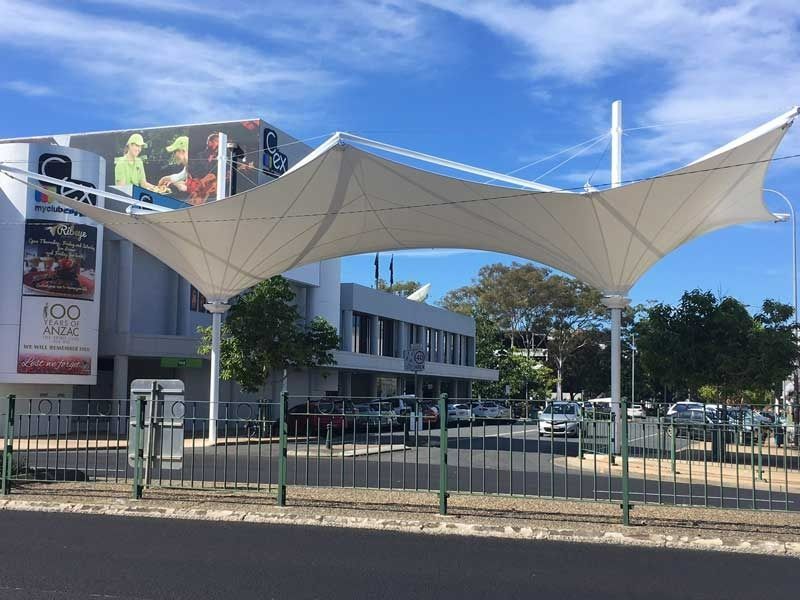A Large White Umbrella Is Sitting in Front of A Building — Jon Wilson Canvas & Shade in Coffs Harbour, NSW