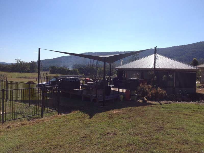 A House with A Fence and A Shade Sail in Front of It — Jon Wilson Canvas & Shade in Coffs Harbour, NSW