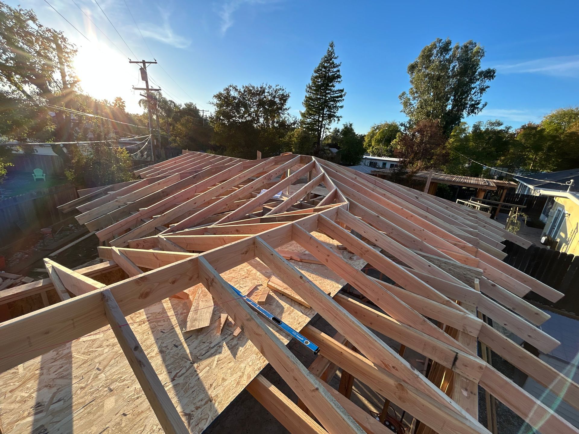 Partially built roof trusses on a house under construction at sunset