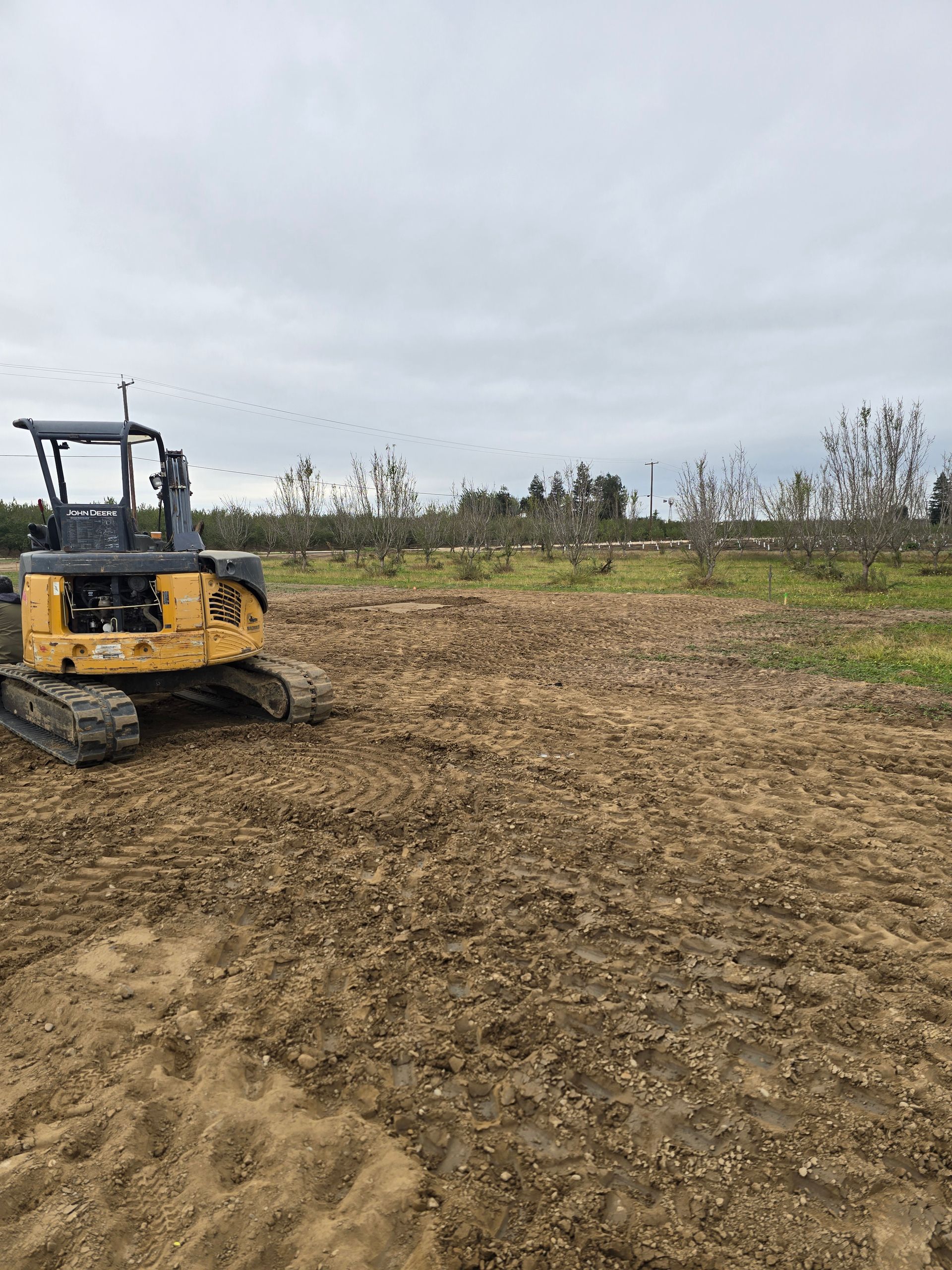 Yellow bulldozer on a muddy construction site under an overcast sky